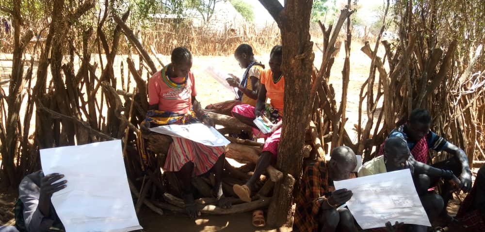 Empowering women in livestock value chain; Tepeth women learning animal husbandry practices through posters. Photo Credit: Gordon Obin , GUCC